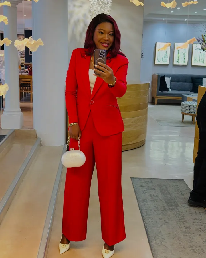 Colette in a red trouser suit